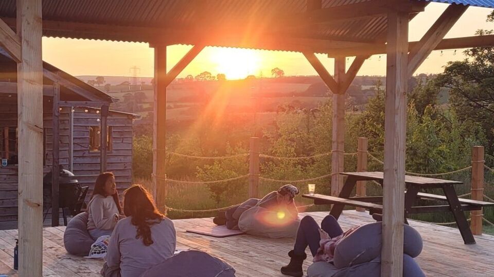 A group of people sitting on bean bags at sunset